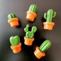een groep koelkastmagneetjes als plastic cactussen in potten