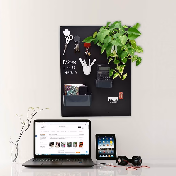 Groot magneetbord in zwarte kleur met diverse magnetische bakjes en met krijtstift beschreven