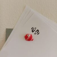 Stapeltje vellen papier vastgehouden met decoratie magneet