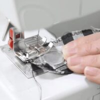 Naaimagneet met schijfmagneet in siliconen hoesje dat in stof genaaid wordt