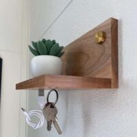 Zijaanzicht van het houten sleutelplankje en het messing ophangmateriaal