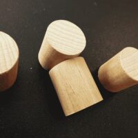 Houten magneet cilinder op een zwart magneetbord