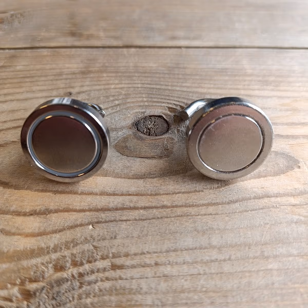 Twee magneten naast elkaar als vergelijk tussen de Action magneet haak en een professionele haak