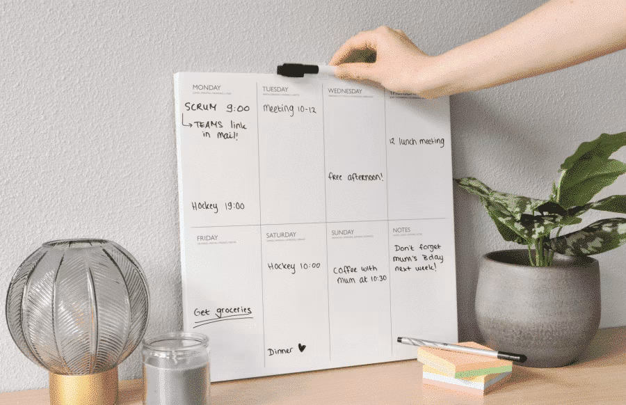 Voorbeeld van een ingevulde whiteboard weekplanner in het interieur van bijvoorbeeld een thuiskantoor